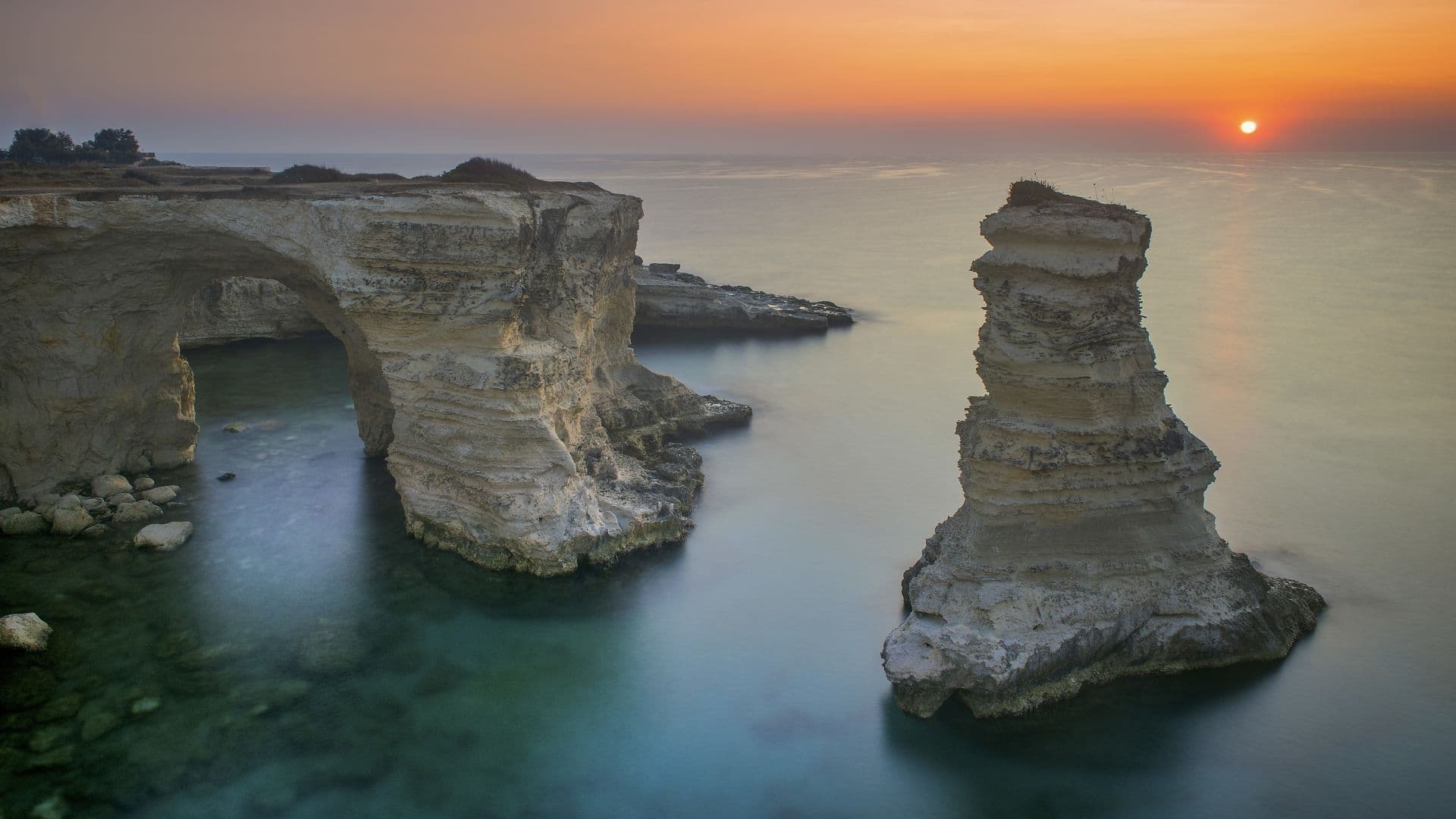 Lebanese Mediterranean coastline with sea stacks glowing at sunset.